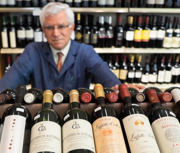 Darrell Corti with bottles of wine at Corti Bros in Sacramento, image