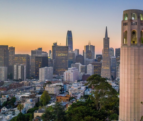 Coit Tower overlooks downtown San Francisco at dawn.