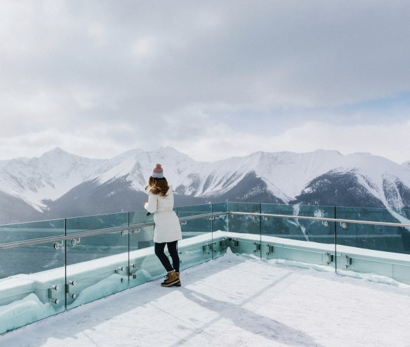 visitor takes in panoramic, view of snow-capped Canadian Rockies from Sulphur Mountain at Banff in Alberta, picture