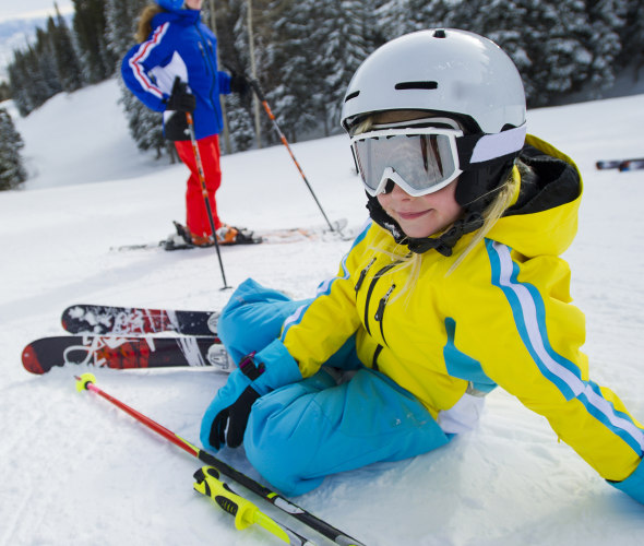 A child rests on a ski slope in Park City, Utah.