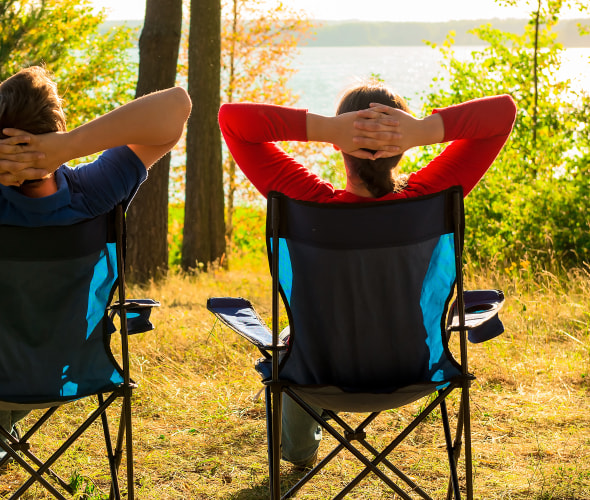 man and woman enjoy the view of a lake while camping, picture