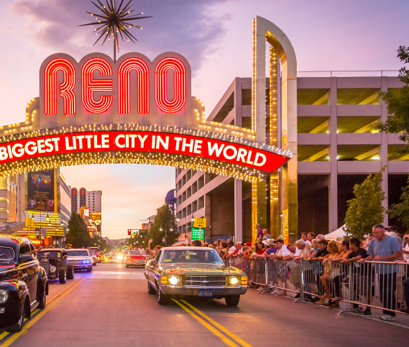 Classic cars drive beneath the famous "The Biggest Little City in the World" sign in Reno, Nevada, photo