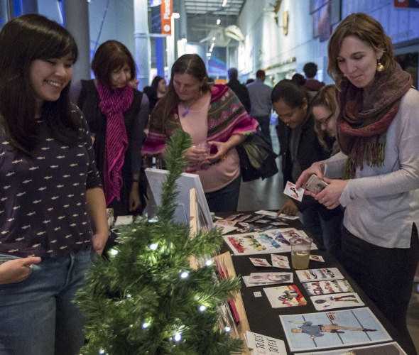 Guests at the California Academy of Science's NightLife Holiday Bazaar event look at a vendor's wares, photo