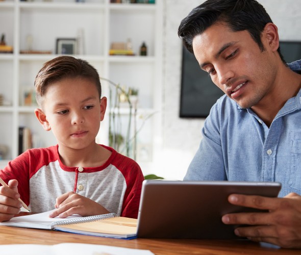 A dad uses a tablet to teach his son.