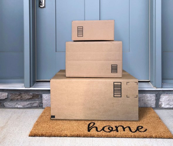 three packages stacked on mat at doorstep