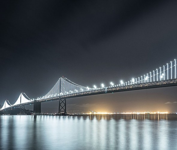 San Francisco Oakland Bay Bridge lit up at night.