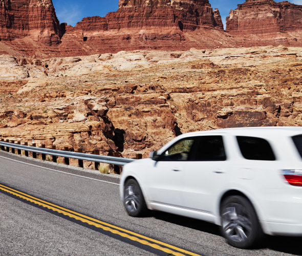 A white SUV drives on a highway in Utah.