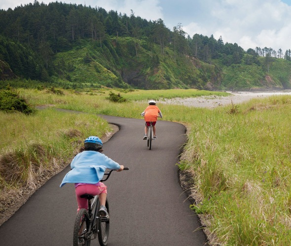 Kids ride their bikes on the paved Discovery Trail in Long Beach, Washington.