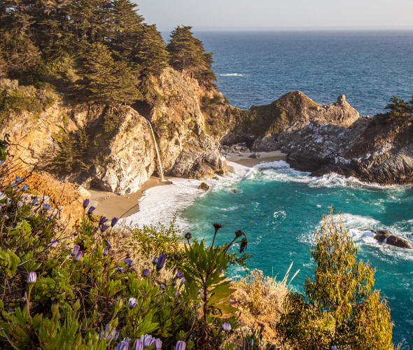 McWay Falls against a turquoise ocean on a sunny day.