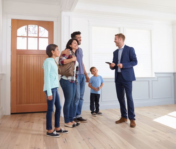 A family tours a house with a real estate agent.