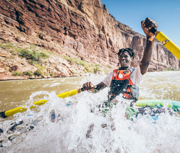 A man rows a raft in Nevills Rapid on the Colorado River in Grand Canyon National Park, Arizona.