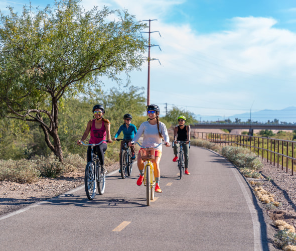 A group of friends ride on a dedicated bike path.