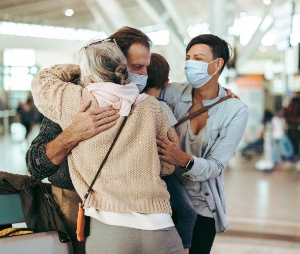 Family members hug inside the airport.