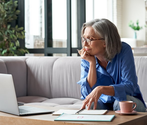 A woman looks at her retirement accounts on her computer.
