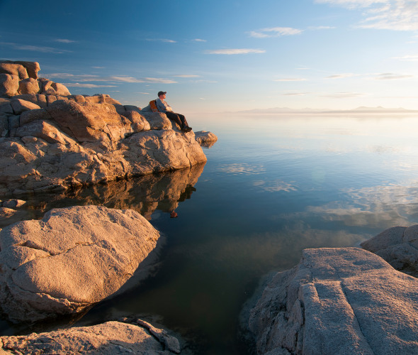 A hiker rests along the shore of the Great Salt Lake from Antelope Island State Park in Utah.
