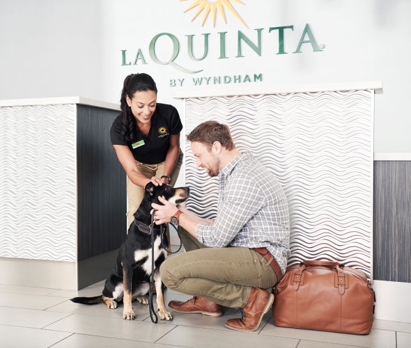 A dog and his family check in at La Quinta by Wyndham.