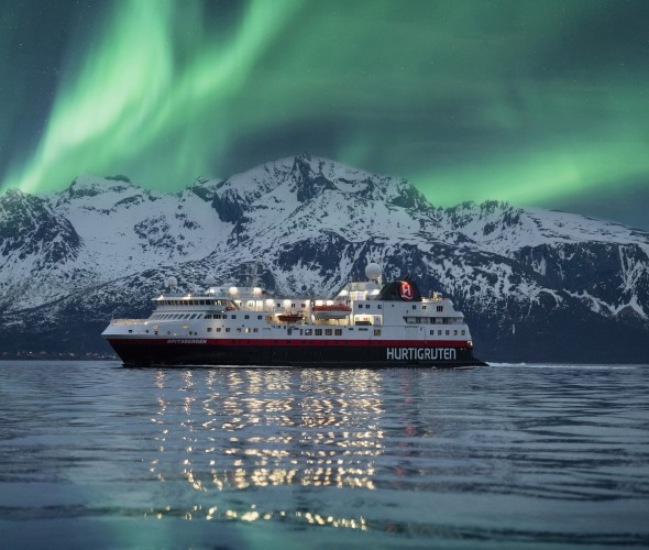 A Hurtigruten Cruise sails under the northern lights.