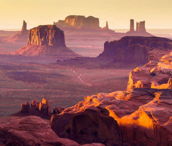 A dirt road winds through Monument Valley Navajo Tribal Park in Arizona.