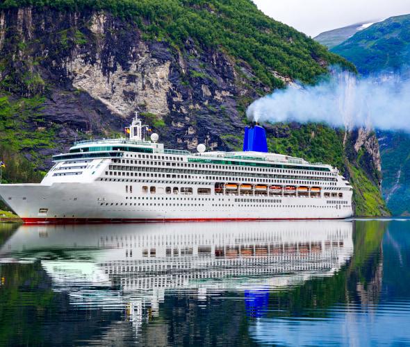 A large cruise ship sails into Geiranger Fjord, Norway.