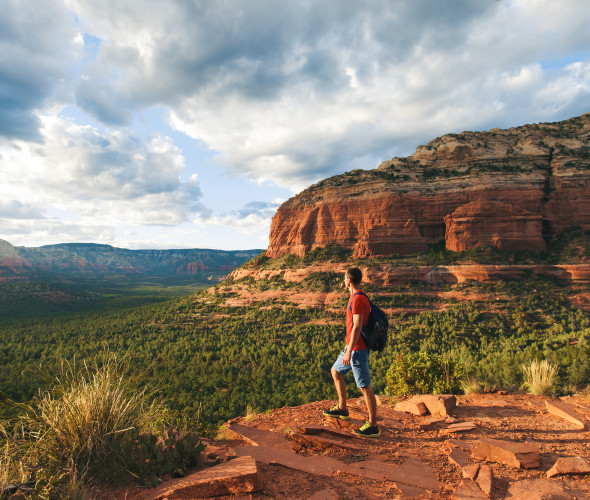 A hiker stands at an overlook in Sedona, Arizona.