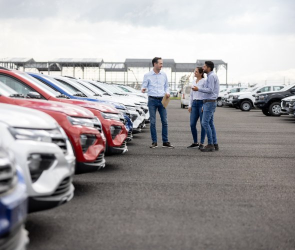 A couple shop for a new vehicle at a car dealership.