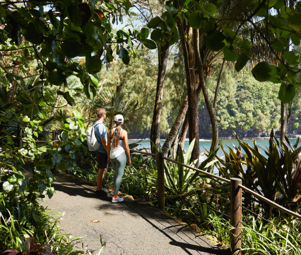 A couple walk through the Hawaii Tropical Botanical Garden.