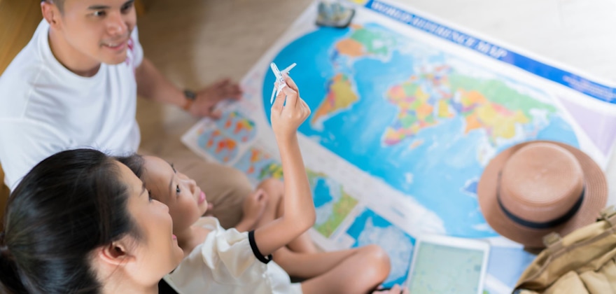 Family planning a vacation in front of a map, picture