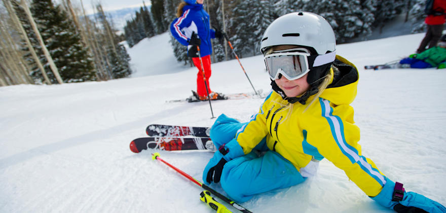 A child rests on a ski slope in Park City, Utah.