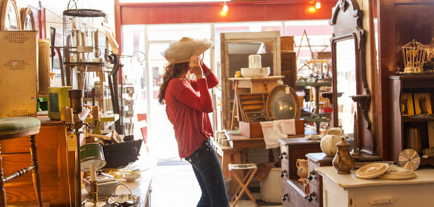 A woman tries on a hat in the Vain & Vintage store in Pocatello, Idaho