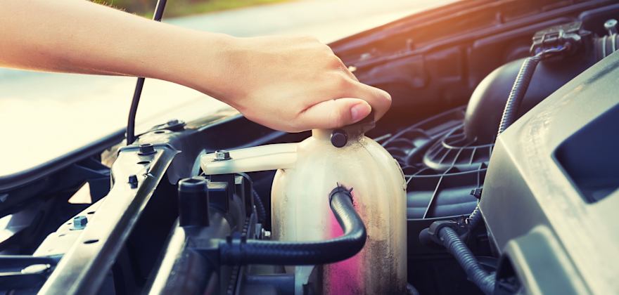 woman checking the level of coolant in her car engine.