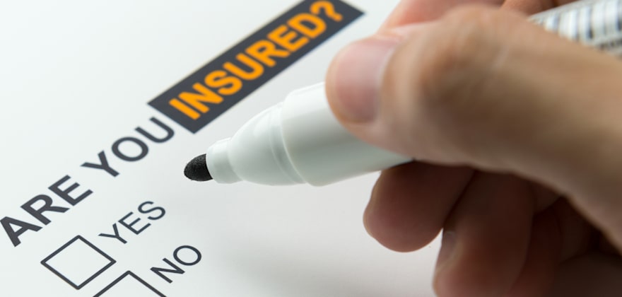 A hand with a pen getting ready to check the 'No' box to the question, Are you insured?