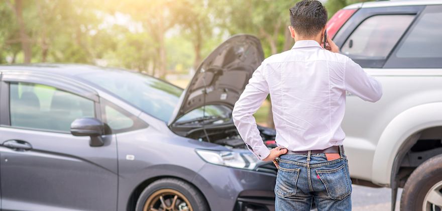 Man is on the phone with AAA Auto Insurance after a car accident