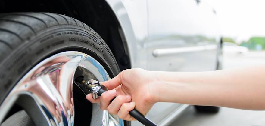 A driver fills front tire with air.