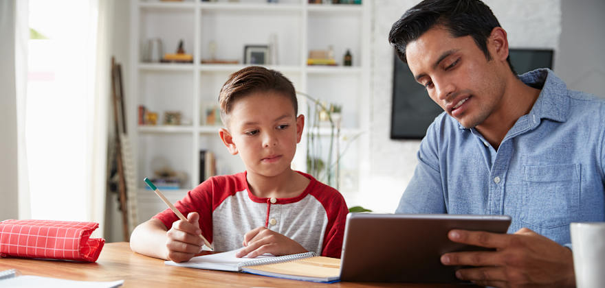 A dad uses a tablet to teach his son.