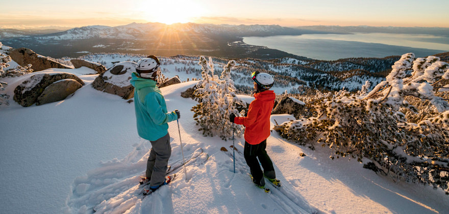 pair of skiers pause for a panoramic view of the winter scenery above Lake Tahoe, California