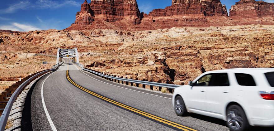 A white SUV drives on a highway in Utah.