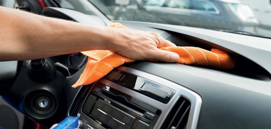 A driver wipes down their dashboard.