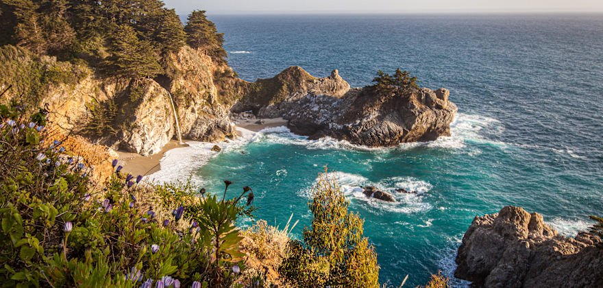 McWay Falls against a turquoise ocean on a sunny day.