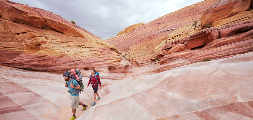 A family hikes through the vibrant rocks at Valley of Fire State Park, Nevada.