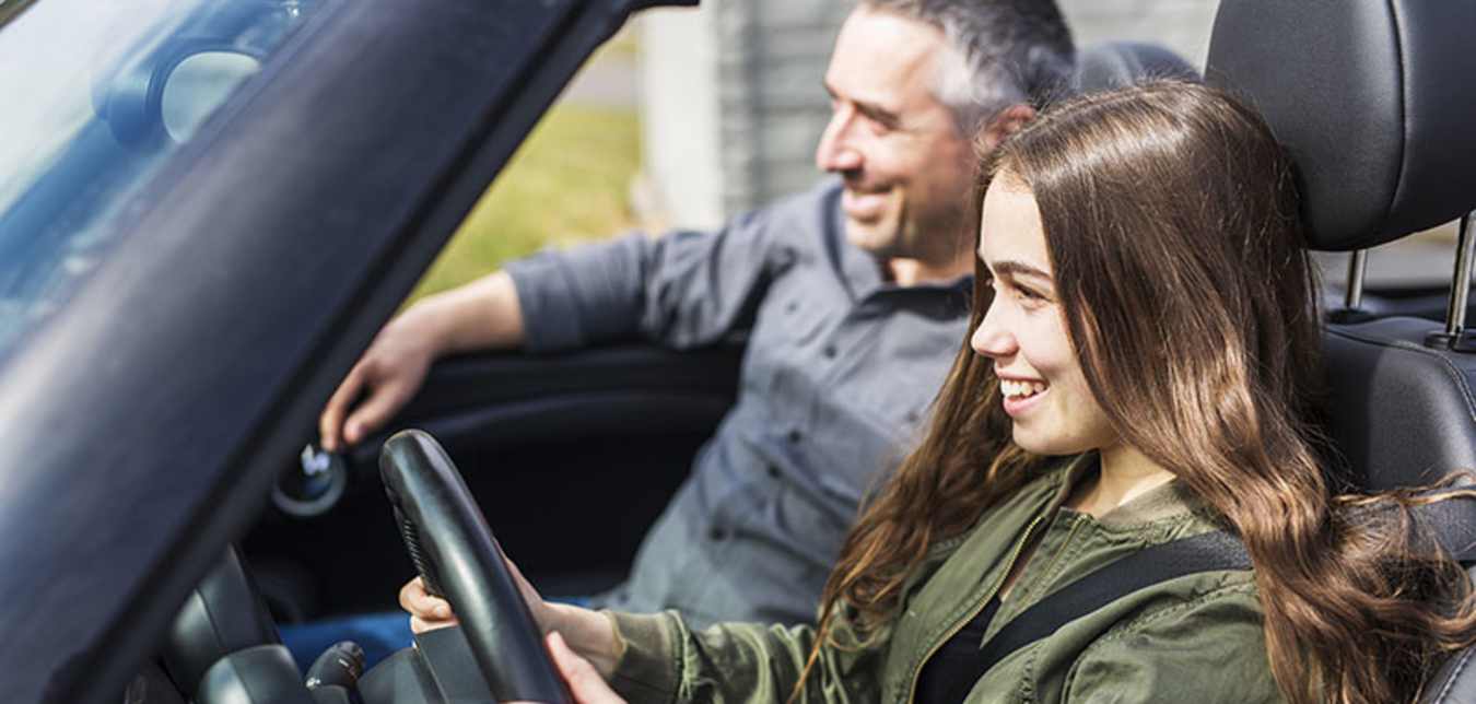 a father sits in the passenger seat with his teen driver with AAA Membership 