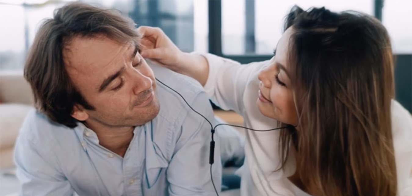 a couple shares headphones from a AAA TV commercial