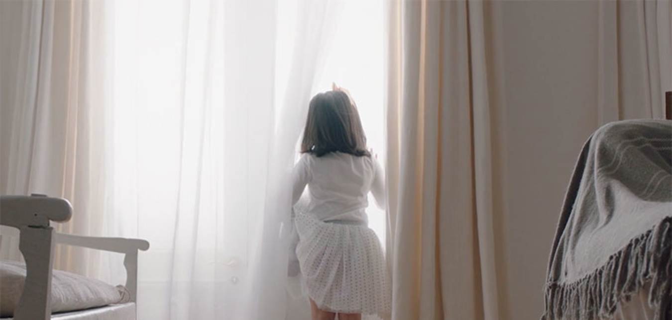 a young girl looks out the window in a AAA Smart Home commercial