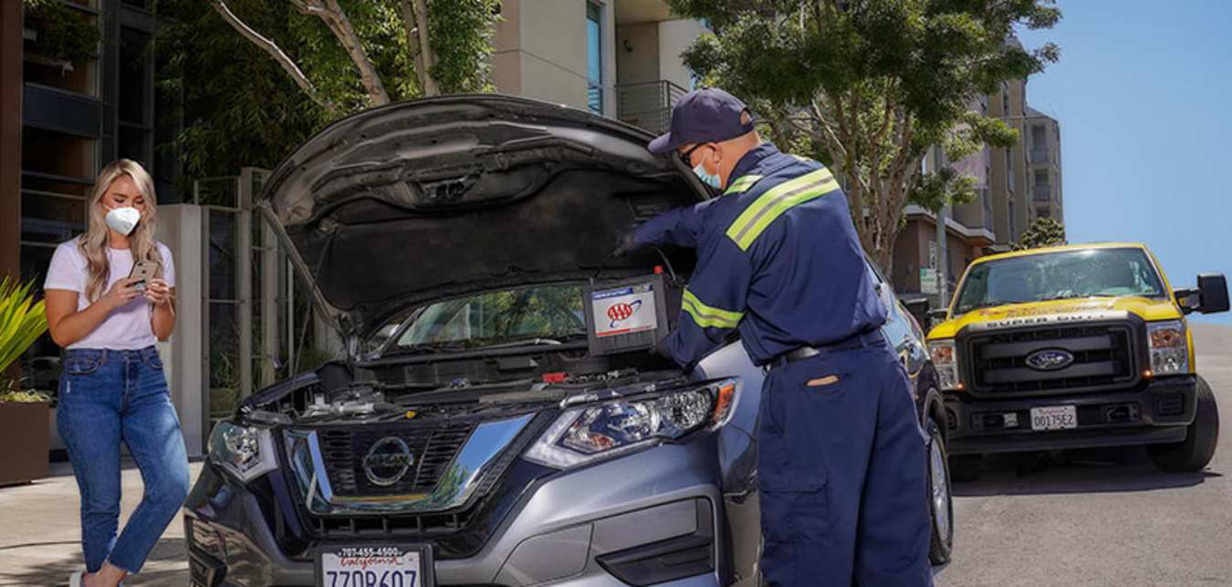 A Member of AAA has her battery replaced by a tow truck driver