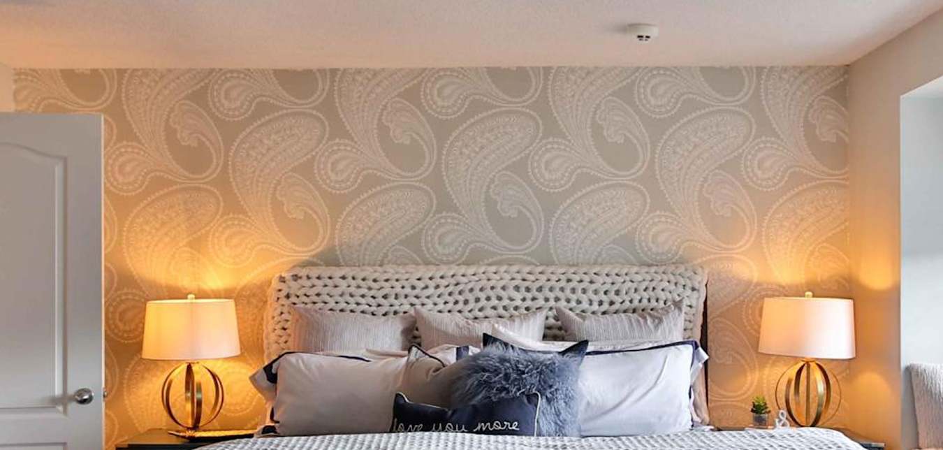 A smoke detector above a bed.