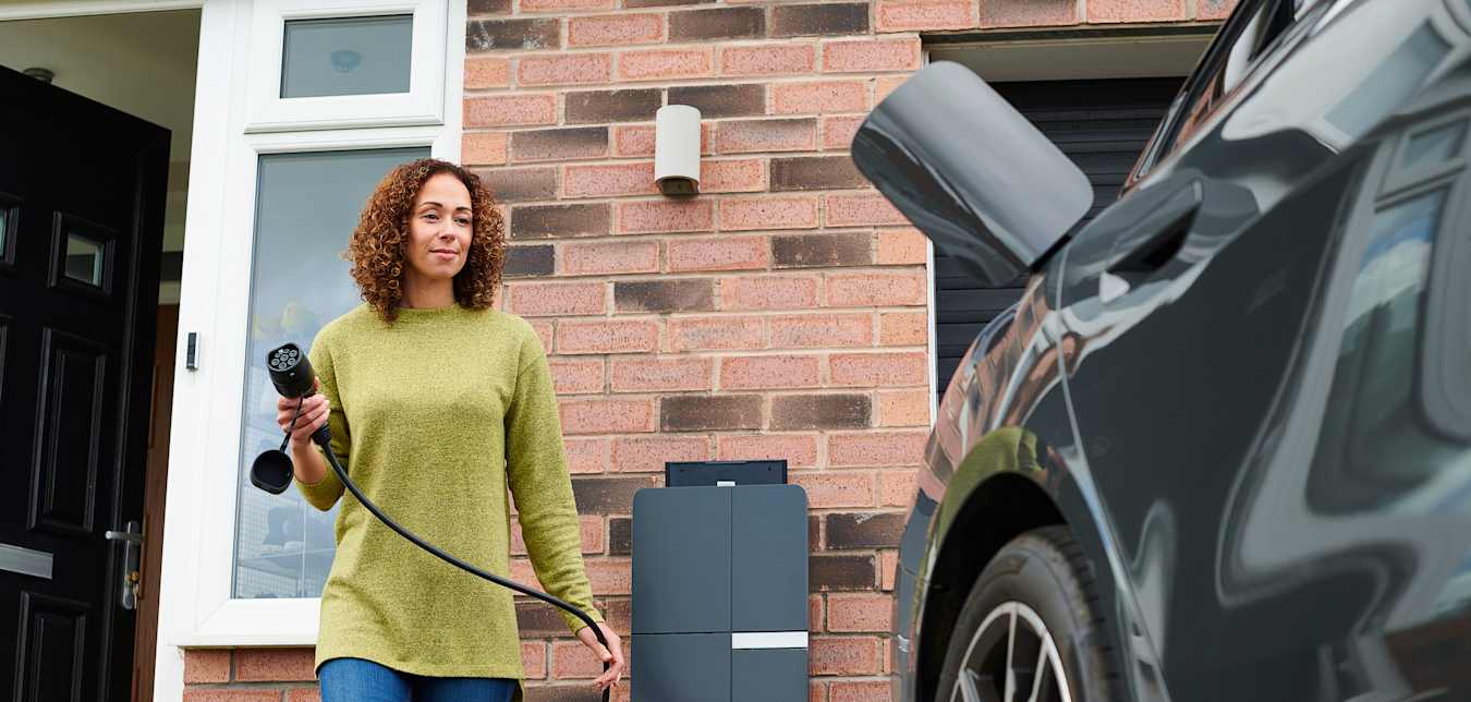 Woman plugging in charger into her EV
