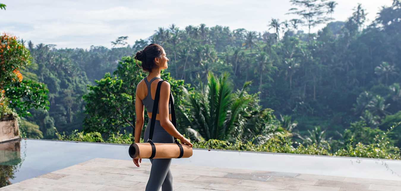 woman with yoga mat relaxing in bali