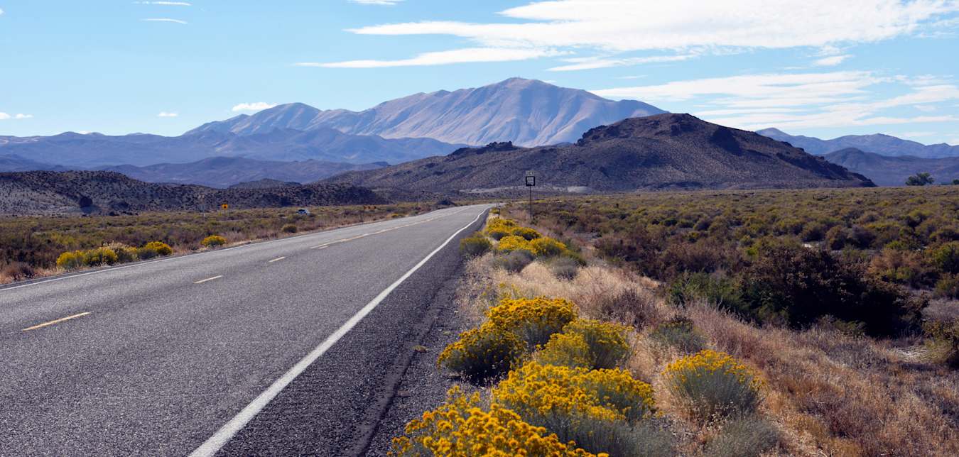 Empty Highway 50 stretches into the Nevada desert on a party cloudy day.