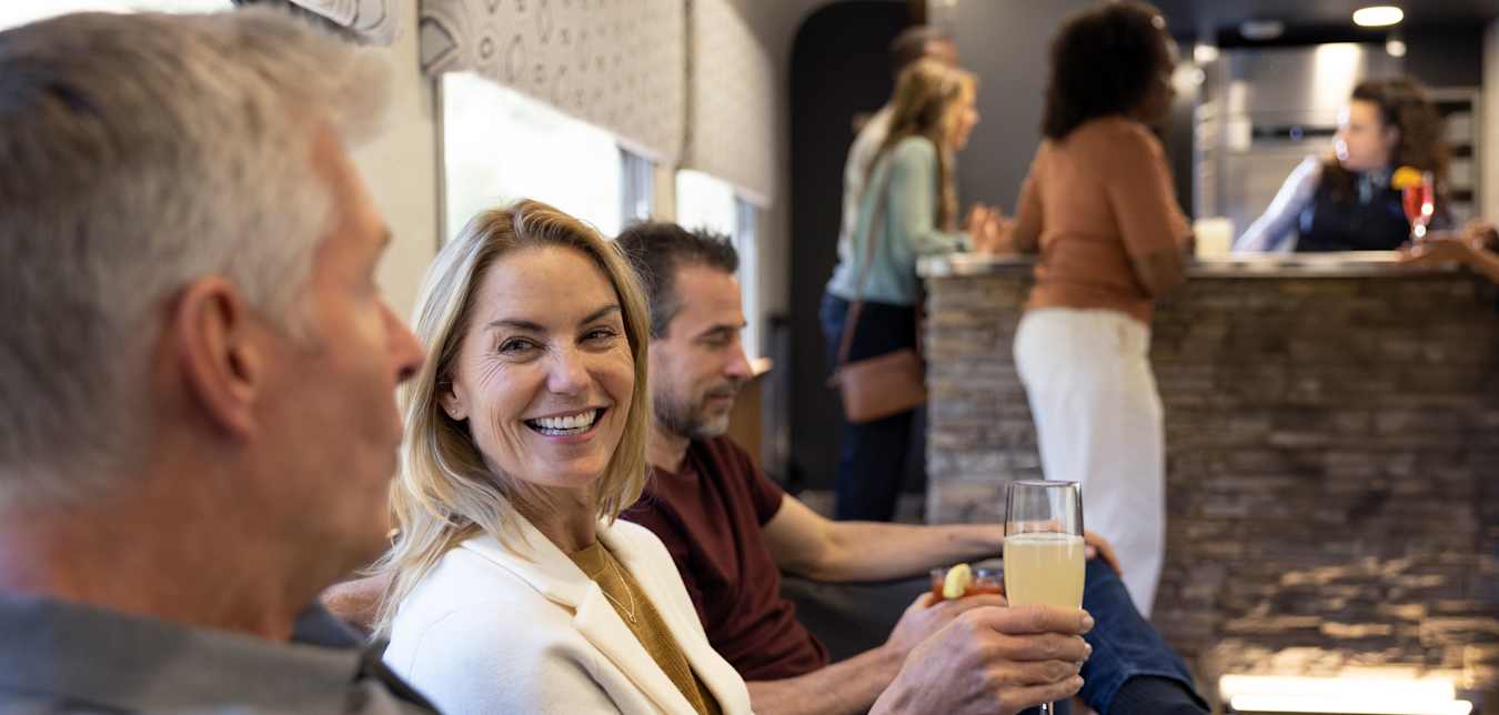 people with cocktails in the lounge car on canyon spirit