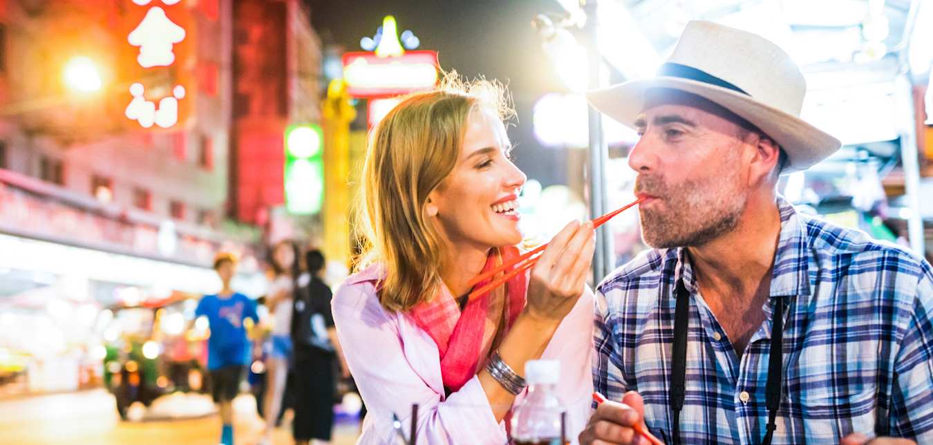 man and woman eating food in thailand