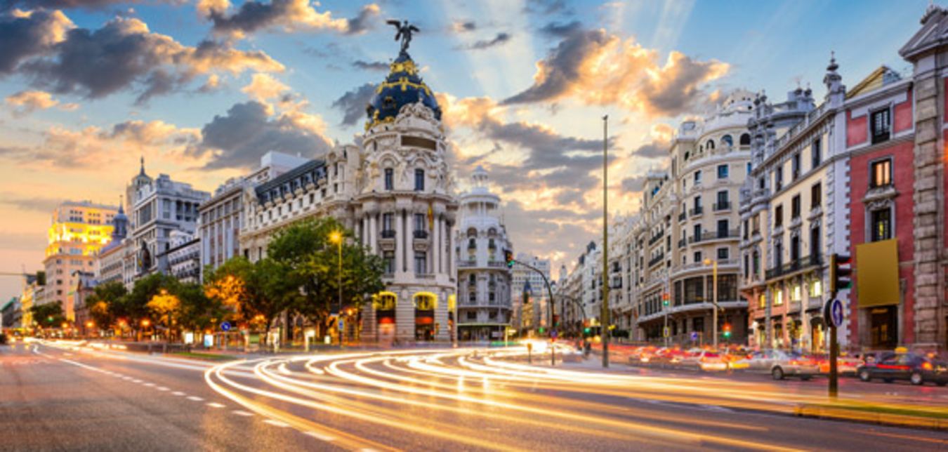 cars drive down an international city street